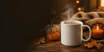 Cozy autumn evening with a steaming coffee mug, candle and pumpkins